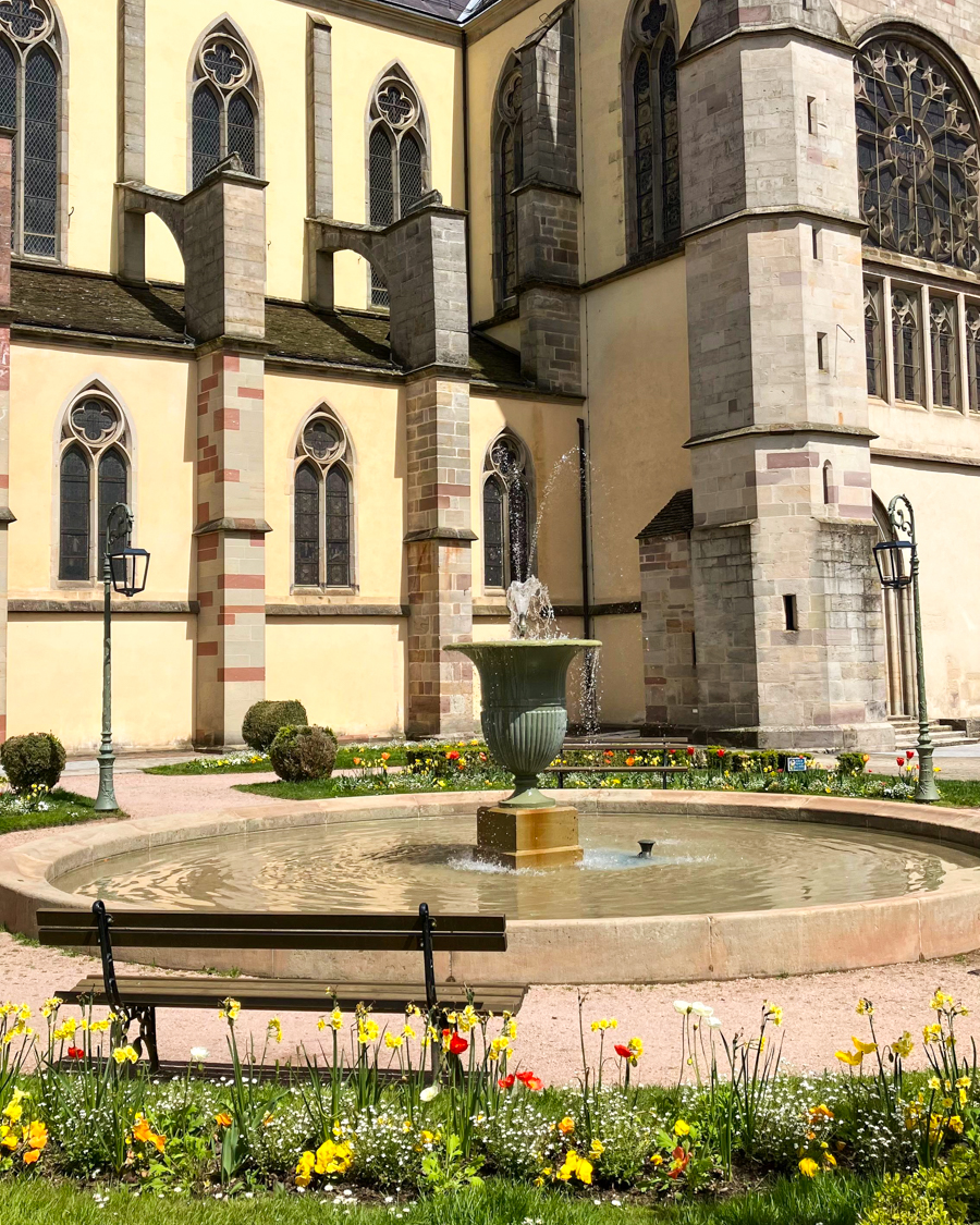 La place de mesdames au printemps, avec sa fontaine et ses fleurs, dans le quartier abbatial de Remiremont